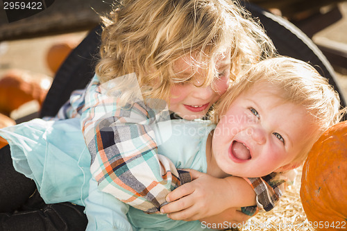 Image of Little Boy Playing with His Baby Sister at Pumpkin Patch