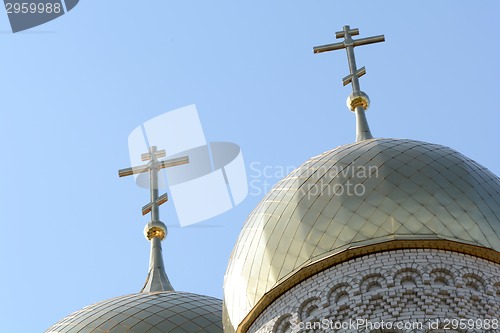 Image of Golden cupola and christian cross on church against blue sky