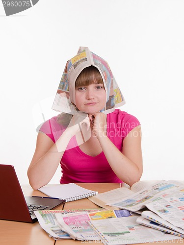 Image of The girl wore a newspaper as headscarf