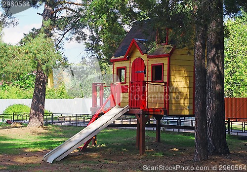 Image of Bright children's wooden house with slide