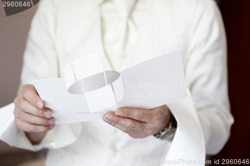 Image of Groom is reading a white greeting card