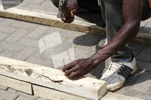 Image of African carpenter works with wood