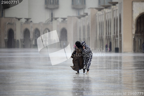 Image of Two Moroccans run through the rain