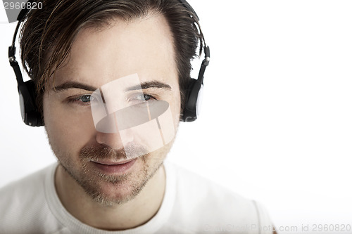 Image of Attractive man with headphones in front of a white background en