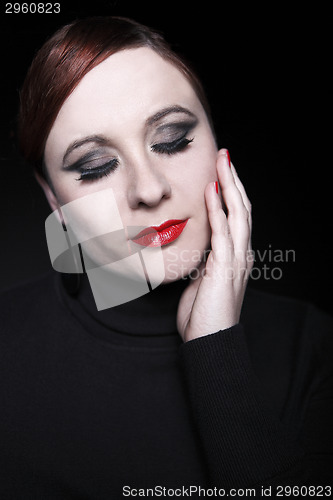 Image of Young woman with red lips and black pullover