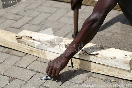 Image of African carpenter works with wood
