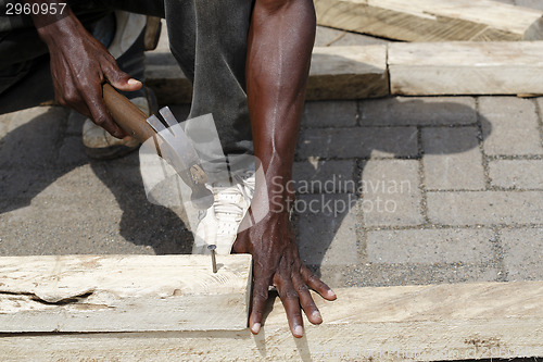 Image of African carpenter works with wood