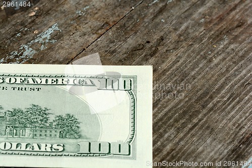 Image of Close-up of a $100 banknotes on wooden background