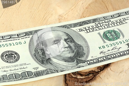 Image of One hundred dollars banknotes on wooden background