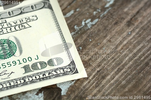 Image of Hundreds of US dollars on old wooden background