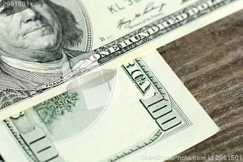 Image of One hundred dollars on wood background