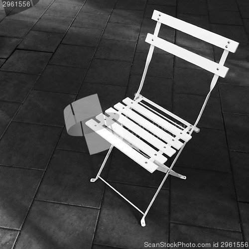 Image of White foldable chair on dark background