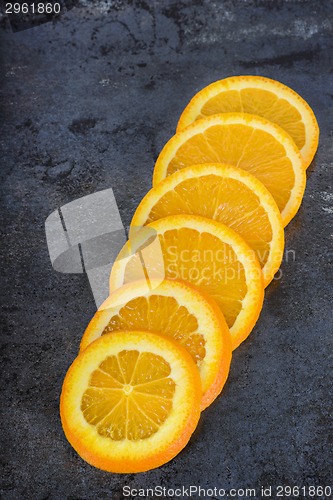 Image of Orange slices arranged on a dark background