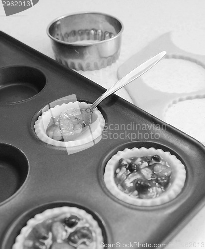 Image of Using teaspoon to fill pastry cases with mincemeat