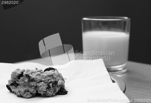 Image of Freshly baked oatmeal raisin cookie with a glass of milk