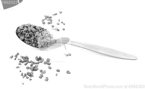 Image of Teaspoon of instant coffee, some granules spilled 