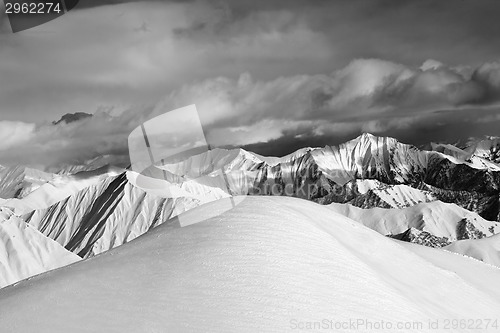 Image of Black and white  off-piste snowy slope and cloudy mountains