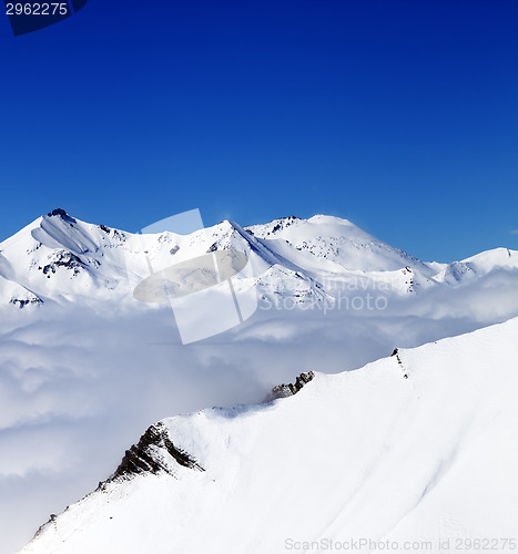 Image of Mountains in clouds at nice day. View from ski slope.