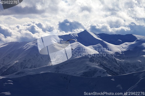 Image of Skydiver at evening cloudy mountains