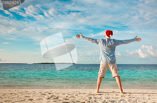 Image of Man in santa hat on the tropical beach