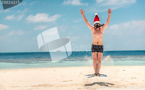 Image of Man in santa hat on the tropical beach