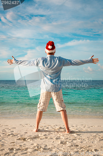 Image of Man in santa hat on the tropical beach