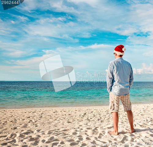 Image of Man in santa hat on the tropical beach