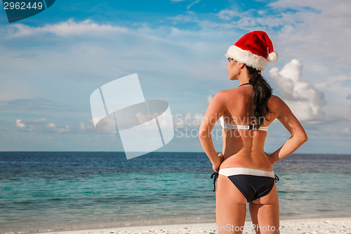 Image of Woman in santa hat on the beach