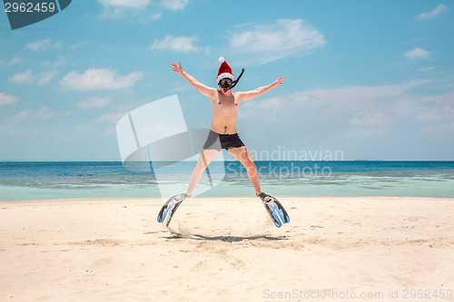 Image of Man in santa hat on the tropical beach