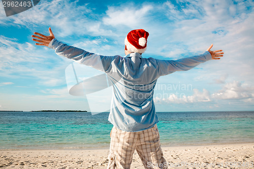 Image of Man in santa hat on the tropical beach