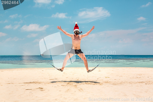 Image of Man in santa hat on the tropical beach