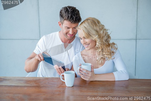 Image of Man showing his wife something on a tablet