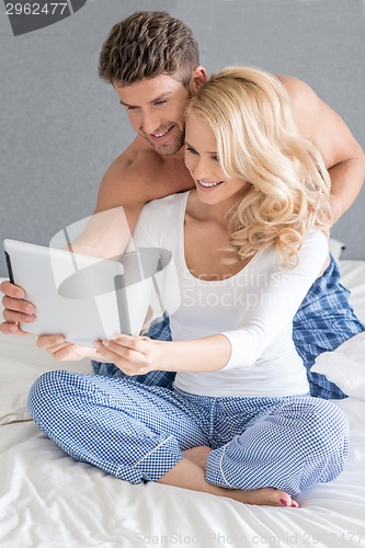 Image of Excited couple reading a tablet computer