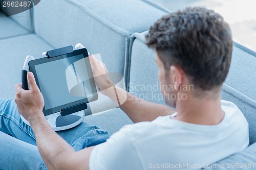 Image of Middle Age Man Using Cool Tablet at Couch