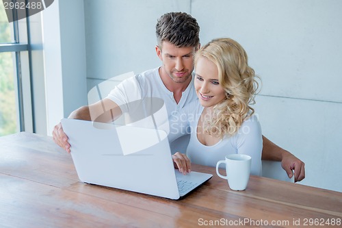 Image of Young couple surfing the web on a laptop