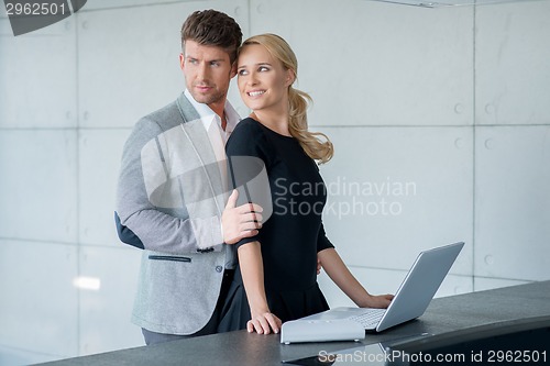 Image of Couple Fashion Shoot at Long Table with Laptop