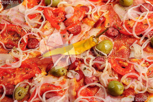 Image of Pizza with tomato, salami, peppeeoni, olives and yellow hot pepper
