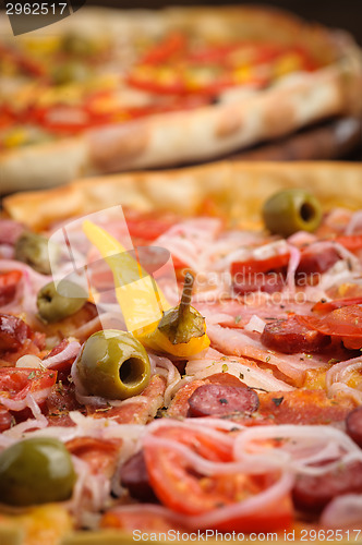 Image of Pizza with tomato, salami, peppeeoni, olives and yellow hot pepper