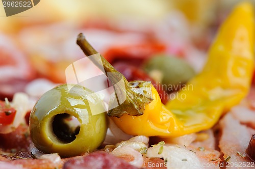 Image of Pizza with tomato, salami, peppeeoni, olives and yellow hot pepper