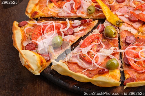 Image of Pizza with tomato, salami, peppeeoni, olives and yellow hot pepper