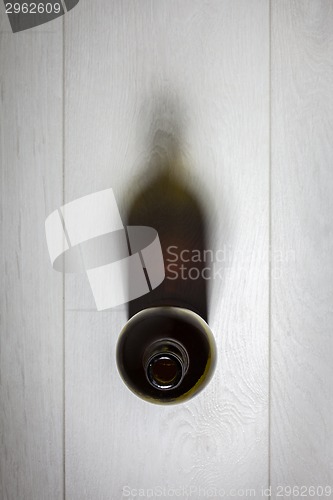 Image of Bottle of red wine with cork on white wooden table