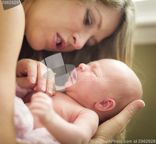 Image of Young Beautiful Mother Holding Her Precious Newborn Baby Girl