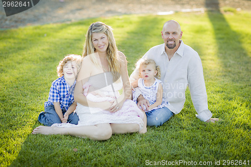 Image of Beautiful Young Family Portrait Outside on Grass