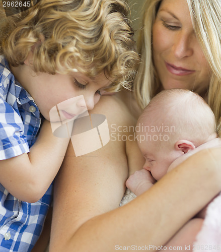 Image of Young Mother Holds Newborn Baby Girl as Brother Looks On