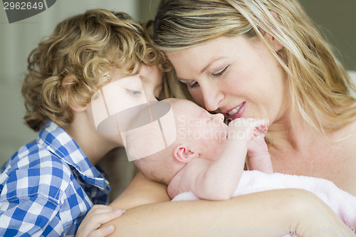 Image of Young Mother Holds Newborn Baby Girl as Brother Looks On