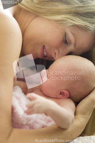 Image of Young Beautiful Mother Holding Her Precious Newborn Baby Girl