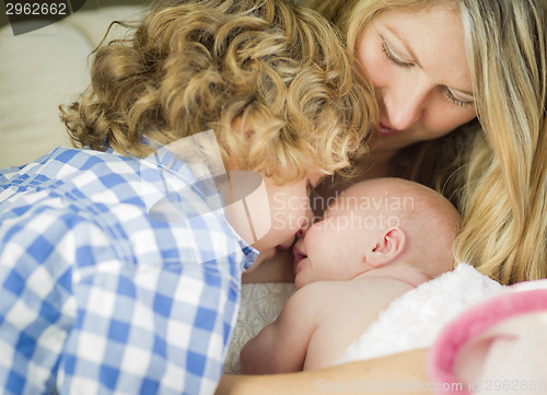 Image of Young Mother Holds Newborn Baby Girl as Brother Looks On