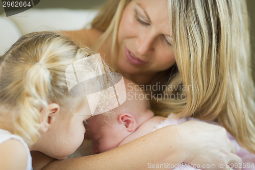 Image of Young Mother Holds Newborn Baby Girl with Young Sister