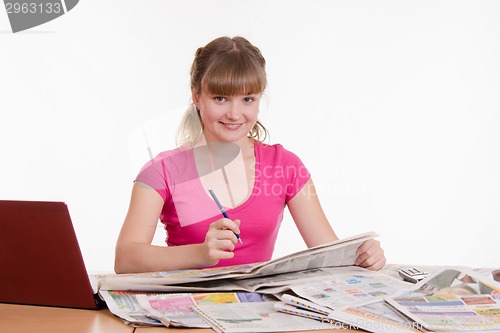 Image of Girl looking in the newspaper classifieds