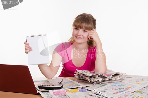 Image of Girl shows record on a notepad while sitting at table